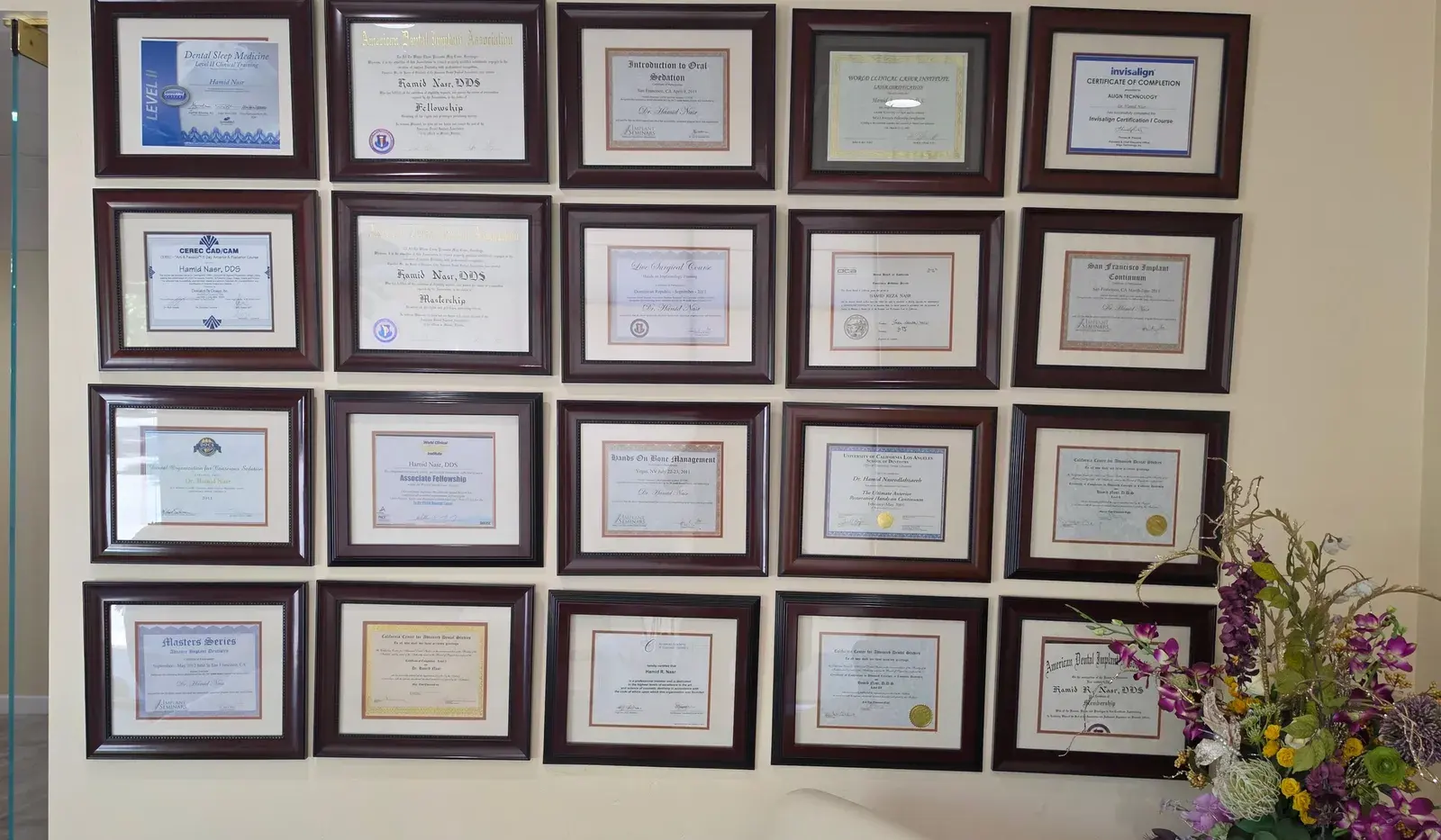 Dr. Nasr's wall of implant fellowships and continuing-education certifications at the Folsom office