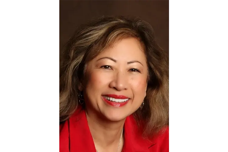 The same patient in a red jacket smiling after treatment