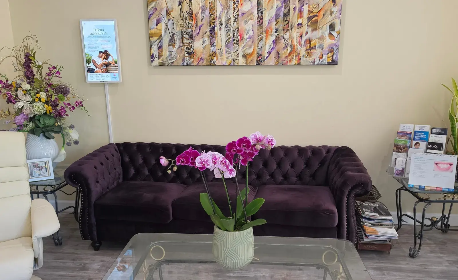 The Creekside Dentistry waiting lounge — velvet sofa, orchids, and artwork on East Bidwell